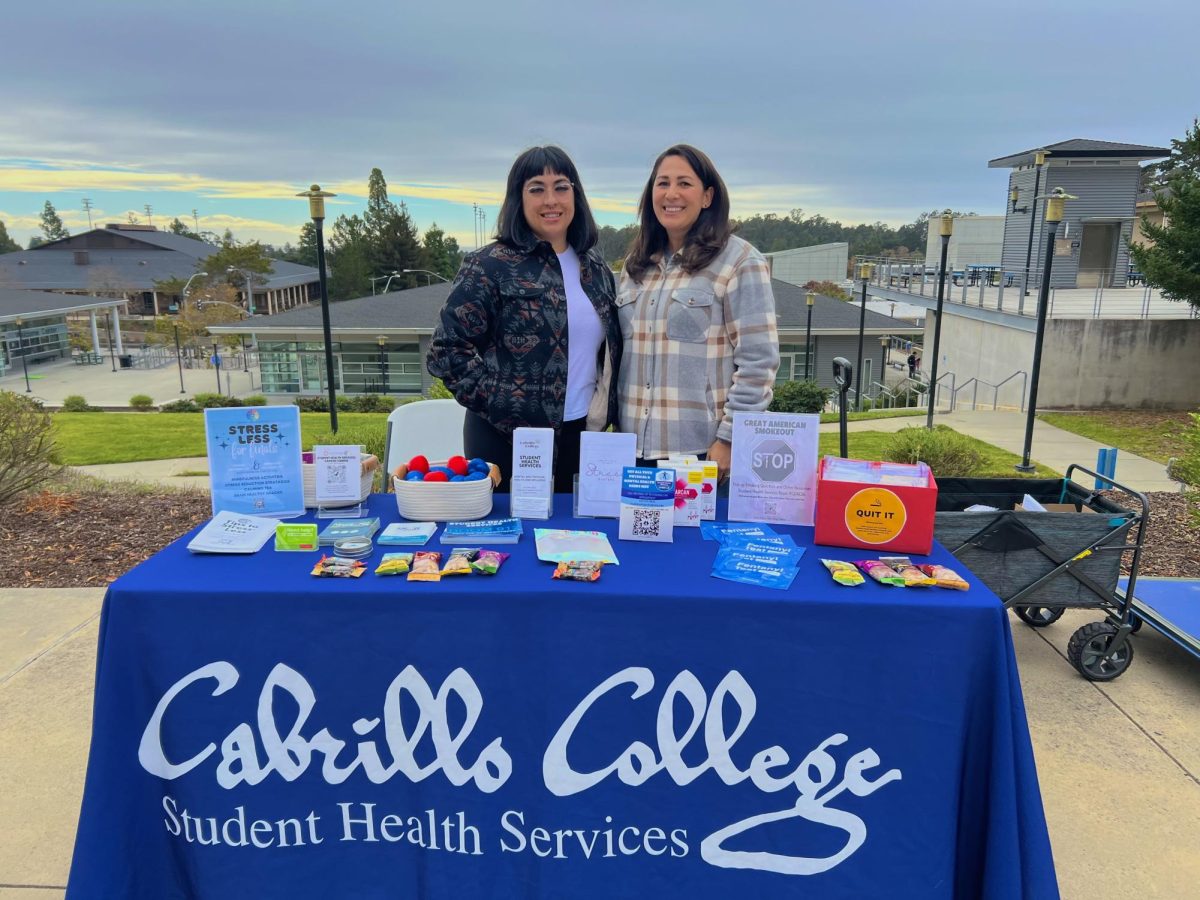 Bridgette Madrilla and Claudia Peixoto managing the quit smoking table near the library. 